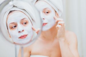 kvinna lägger ansiktsmask