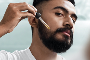 Skäggig man tar serum skäggolja bra för ansiksthår